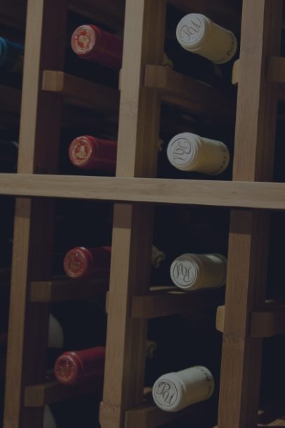 Wine bottles rest in a cellar that has been treated with professional wine organization from Domaine.