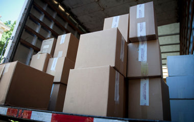 A stack of boxes with wine bottles in a refrigerated moving truck.