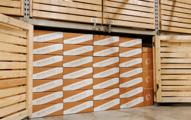 A Domaine wooden storage locker filled with boxes of stored wine, which were delivered with Domaine PickUp.