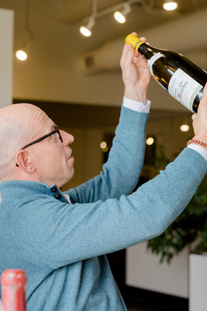 Marc Lazar (founder of Domaine) inspects a bottle for wine appraisals.